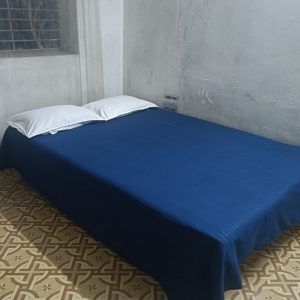 Left view of dormitory beds at Hotel Kalzug, Katihar – affordable stay for men with comfortable sleeping arrangements.